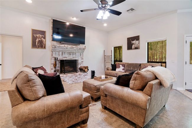 Living room with ceiling fan, a fireplace, crown molding, and recessed lighting | Image 4