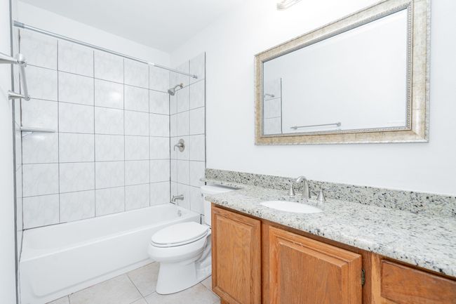Full bathroom with tile patterned floors, bathing tub / shower combination, vanity, and toilet | Image 34