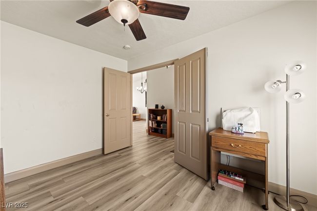 Bedroom with light wood-type flooring, a chandelier, and a ceiling fan | Image 8