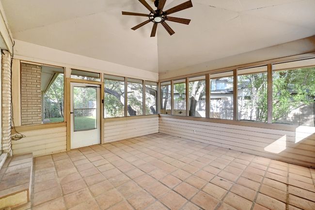 Unfurnished sunroom featuring tile patterned floors and high vaulted ceiling | Image 24