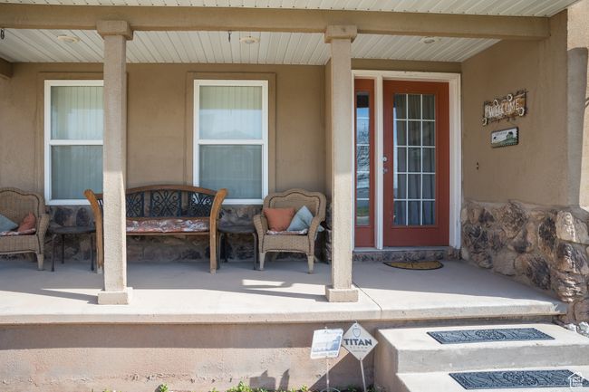 Doorway to property featuring stucco siding and covered porch | Image 47