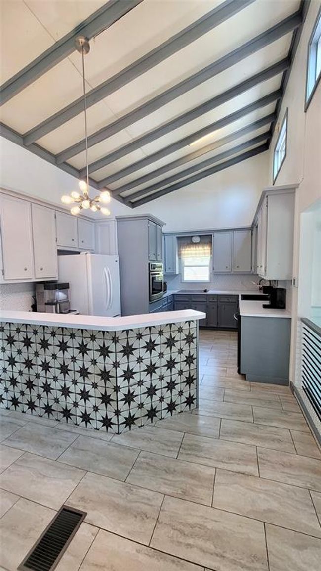 Breakfast bar with decorative tile, vaulted ceiling and windows | Image 8