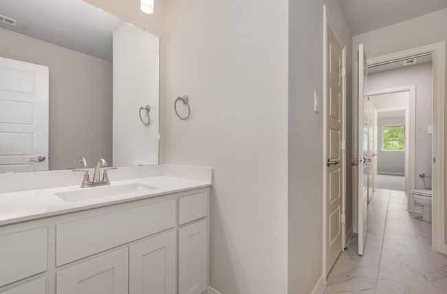 Bathroom with marble look tile flooring, toilet, and vanity | Image 30