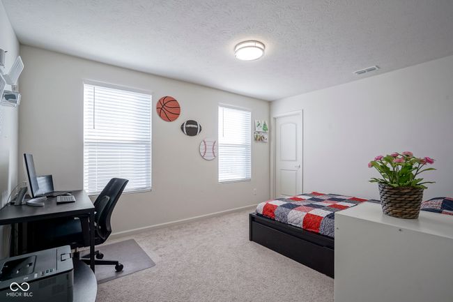 bedroom featuring baseboards, carpet floors, a textured ceiling, and visible vents | Image 33