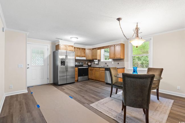 Kitchen with appliances with stainless steel finishes, dark wood-type flooring, decorative backsplash, baseboards, and ornamental molding | Image 21