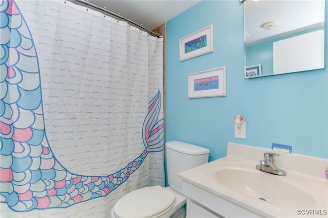 Bathroom with a shower with shower curtain, toilet, and vanity | Image 16