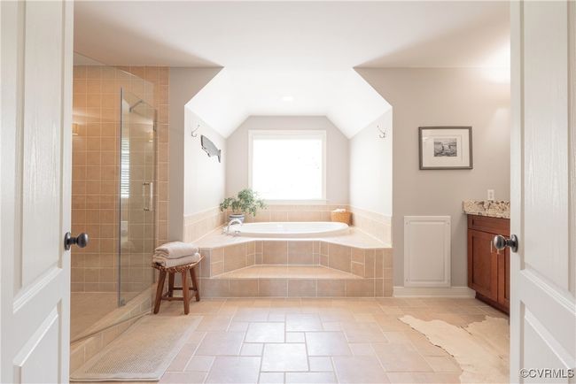 Full bath with a shower stall, a bath, stone tile floors, and vaulted ceiling | Image 34