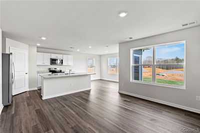 Kitchen featuring stainless steel appliances, dark wood-type flooring, and white cabinetry | Image 3