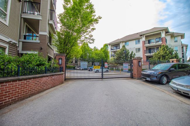View of asphalt street featuring a gate and a gated entry | Image 15