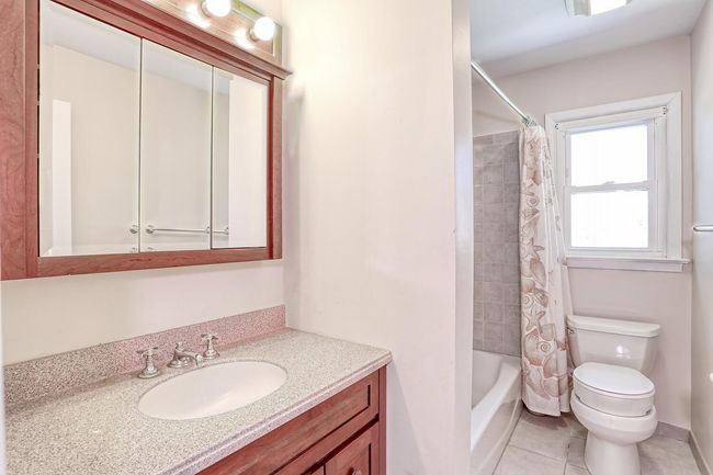 Full bath featuring shower / tub combo, toilet, vanity, and tile patterned floors | Image 24