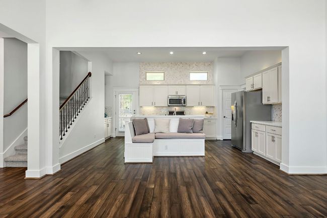 Living area featuring dark wood-style floors, stairway, baseboards, and recessed lighting | Image 9