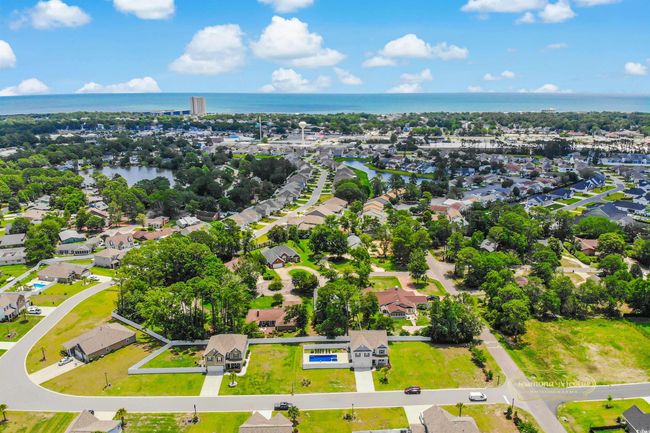 Aerial view of residential area featuring a nearby body of water | Image 4