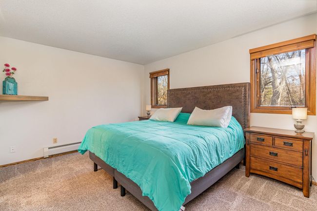 The primary bedroom offers a daily dose of tranquility with stunning wooded views. Sweet dreams meet serene scenes. | Image 22