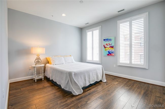 Bedroom featuring recessed lighting, dark wood-style flooring, visible vents, and baseboards | Image 41