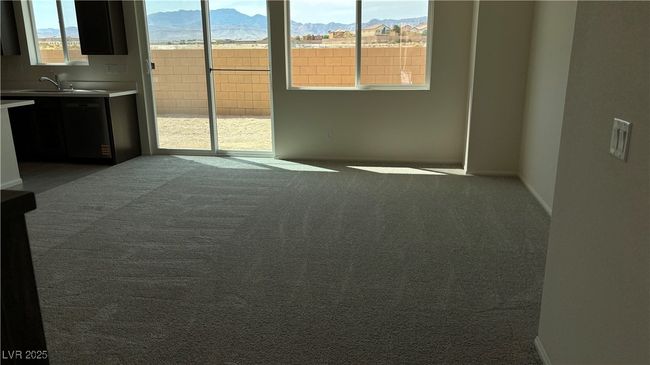 Spare room featuring a mountain view, carpet flooring, and a sink | Image 13