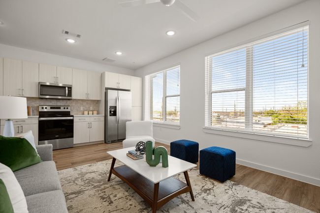 Living room with light wood-style floors, baseboards, visible vents, and a ceiling fan | Image 6