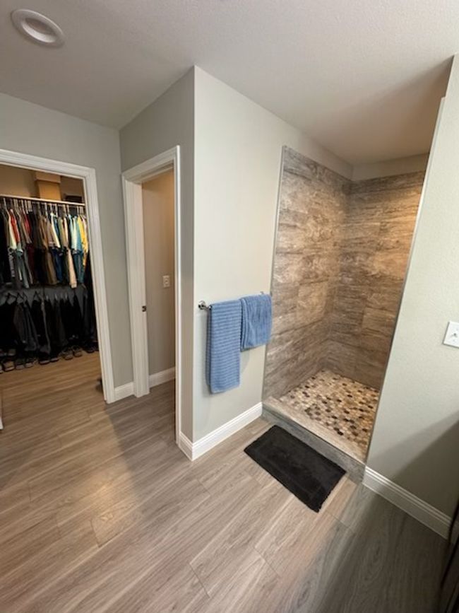 Full bath with a tile shower, wood finished floors, and baseboards | Image 6