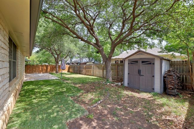 View of yard with a storage shed, a fenced backyard, a patio area, and an outdoor structure | Image 34