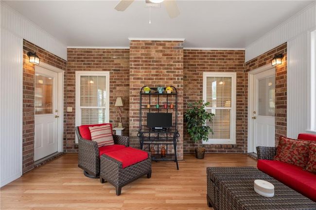 Living room featuring ornamental molding, ceiling fan, wood finished floors, and brick wall | Image 26