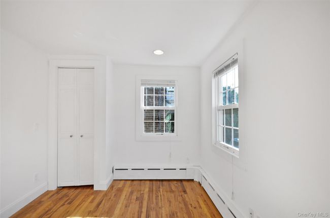 Unfurnished bedroom with light wood-type flooring, recessed lighting, and baseboard heating | Image 4