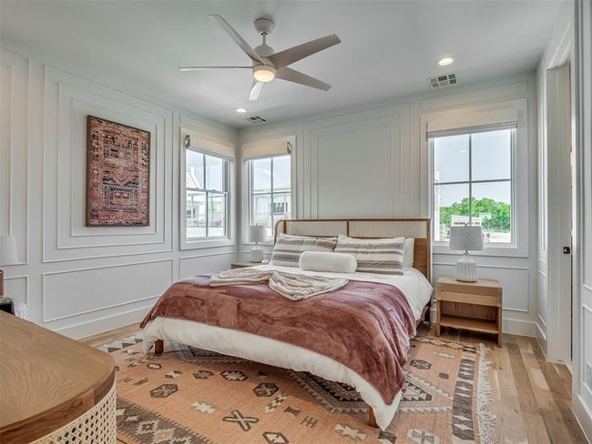 Bedroom with a decorative wall, light wood finished floors, ceiling fan, and recessed lighting | Image 26