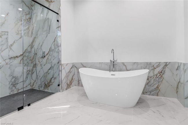 Bathroom featuring tile patterned floors, walk in shower, and tile walls | Image 25