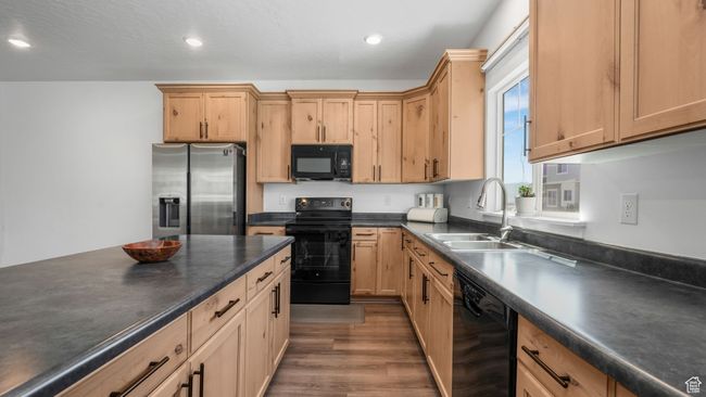 Kitchen featuring black appliances, dark countertops, dark wood finished floors, light brown cabinetry, and recessed lighting | Image 10