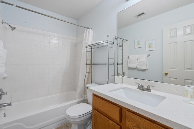 Full bath featuring toilet, vanity, shower / bath combo with shower curtain, and visible vents | Image 27