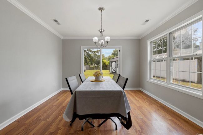 Dining area featuring a chandelier, baseboards, wood finished floors, and ornamental molding | Image 30