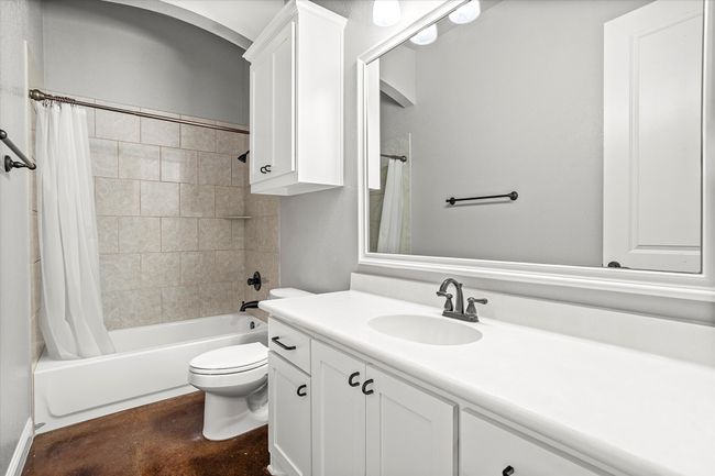 Bathroom featuring vanity, shower / bath combination with curtain, toilet, and concrete floors | Image 27
