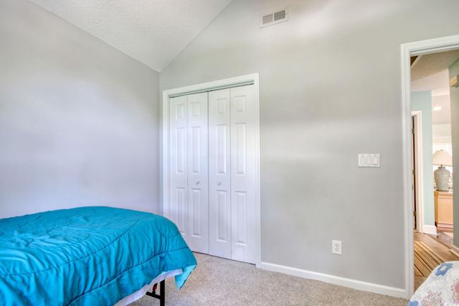 Carpeted bedroom featuring vaulted ceiling, a closet, and a textured ceiling | Image 26