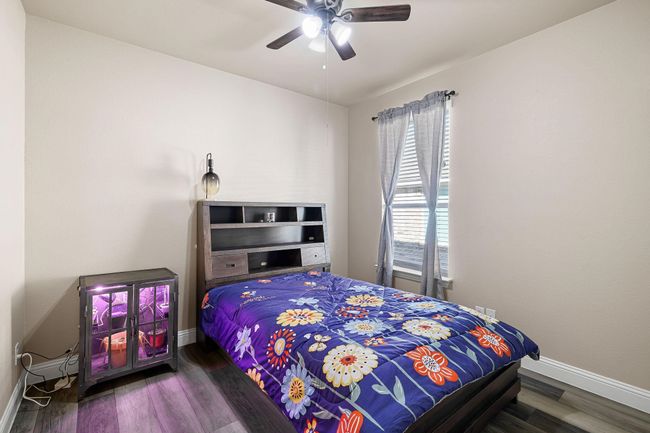 Bedroom featuring wood finished floors, ceiling fan, and baseboards | Image 20