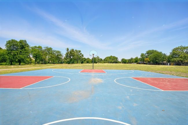 View of sport court with community basketball court, a yard, and view of scattered trees | Image 21