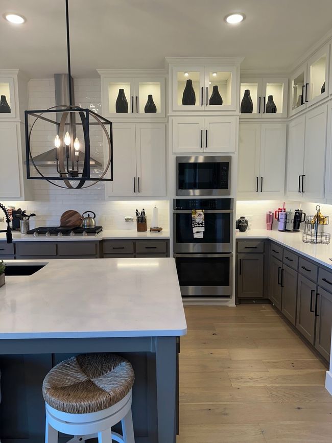 Kitchen with white cabinetry, gray cabinets, light countertops, and decorative light fixtures | Image 14