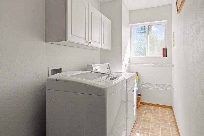 Washroom with cabinet space, washer and clothes dryer, and baseboards | Image 16