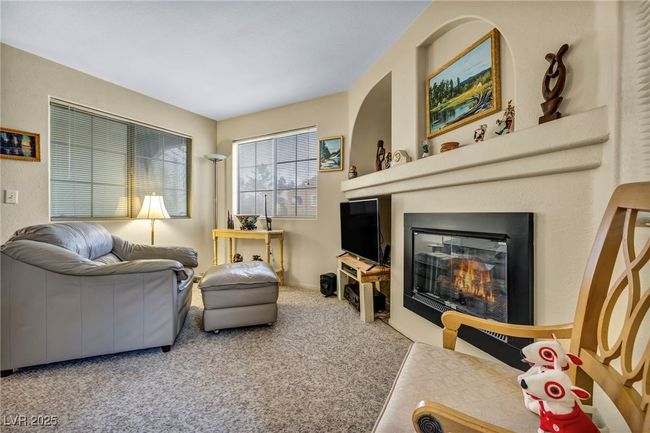 Carpeted living room with a glass covered fireplace | Image 23