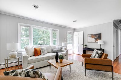 Living room with light hardwood / wood-style floors, baseboard heating, and ornamental molding | Image 2