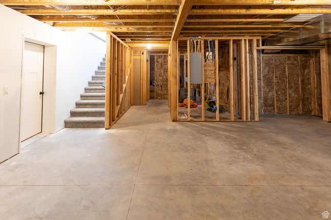 Unfinished basement featuring stairway and water heater | Image 29