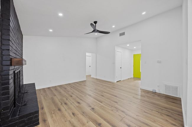 Unfurnished living room featuring a ceiling fan, recessed lighting, light wood-type flooring, and a fireplace | Image 6