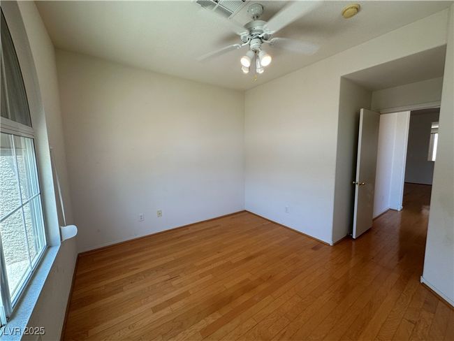 Spare room with light wood-type flooring, a ceiling fan, and a smoke detector | Image 7