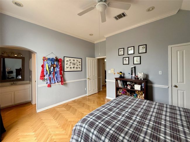 Bedroom featuring crown molding, arched walkways, baseboards, and visible vents | Image 30