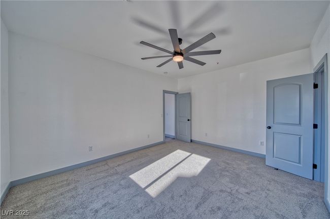 Large primary bedroom featuring custom grey trim and doors throughout, complemented by elegant Onyx fixtures for a modern, refined look. | Image 15