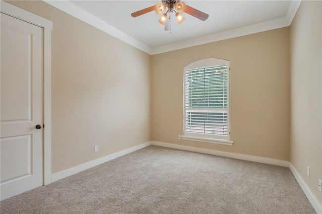 Unfurnished room featuring carpet flooring, crown molding, a ceiling fan, and baseboards | Image 17