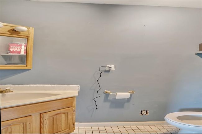 Bathroom featuring baseboards, toilet, vanity, and tile patterned floors | Image 16
