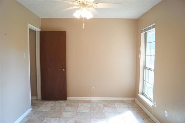 Spare room with healthy amount of natural light, a ceiling fan, and a textured ceiling | Image 13