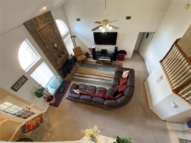 Living room with carpet flooring, a towering ceiling, and ceiling fan | Image 9
