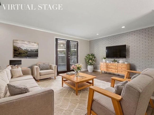 Living room with light wood finished floors, baseboards, recessed lighting, brick wall, and ornamental molding | Image 28