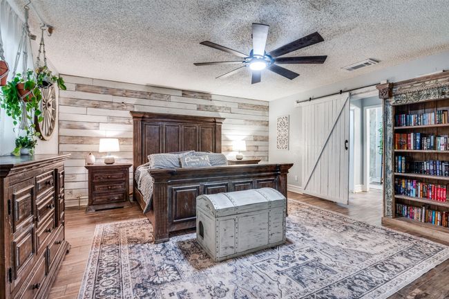 Bedroom with a barn door to ensuite bath, shiplap accent wall | Image 14