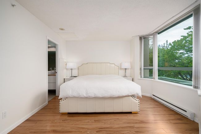 Bedroom featuring a baseboard radiator and light wood-type flooring | Image 11