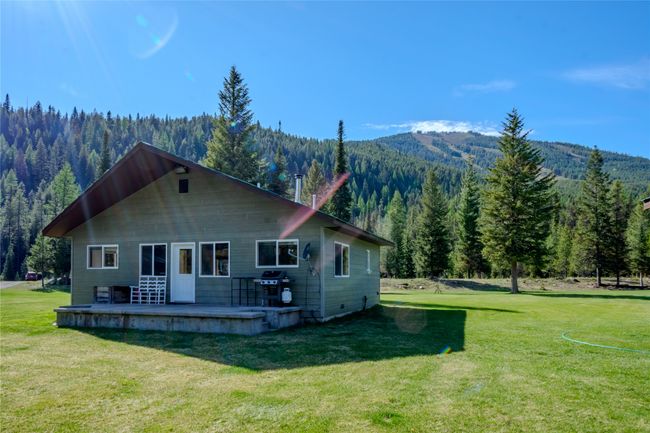 Back of house featuring a wooded view, a mountain view, a patio area, and a yard | Image 37